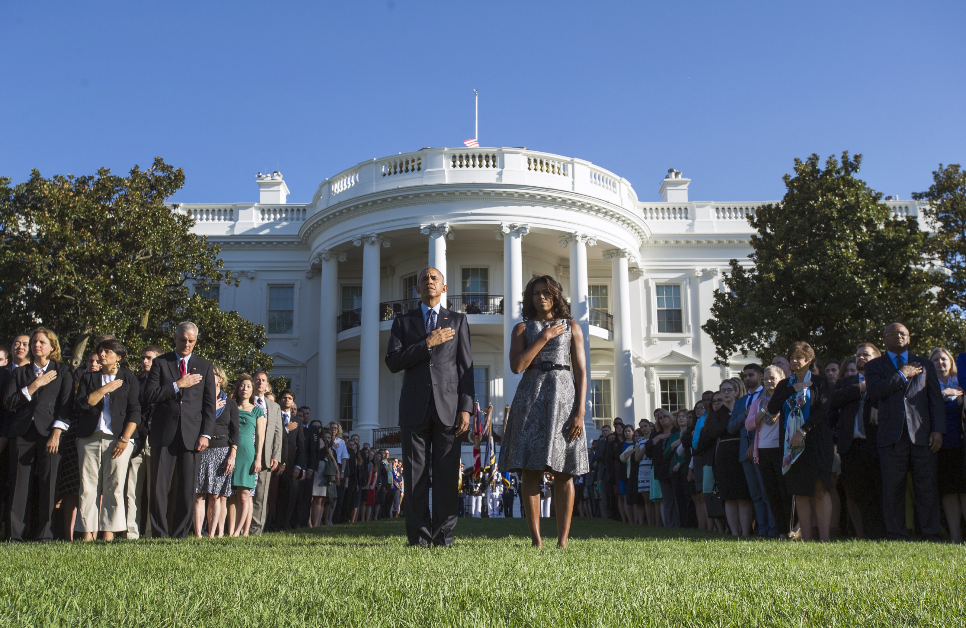 President Barack Obama and First Lady Michelle Obama, joined by White House staff, stand as Taps is played on the 14th anniversary of the September 11 terrorist attacks on the United States, at the White House in Washington, D.C. on September 11, 2015. Photo by Kevin Dietsch/UPI/ABACAPRESS.COM